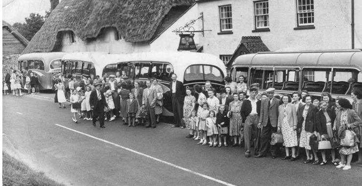 Crowd and coaches outside the pub in the 1950s