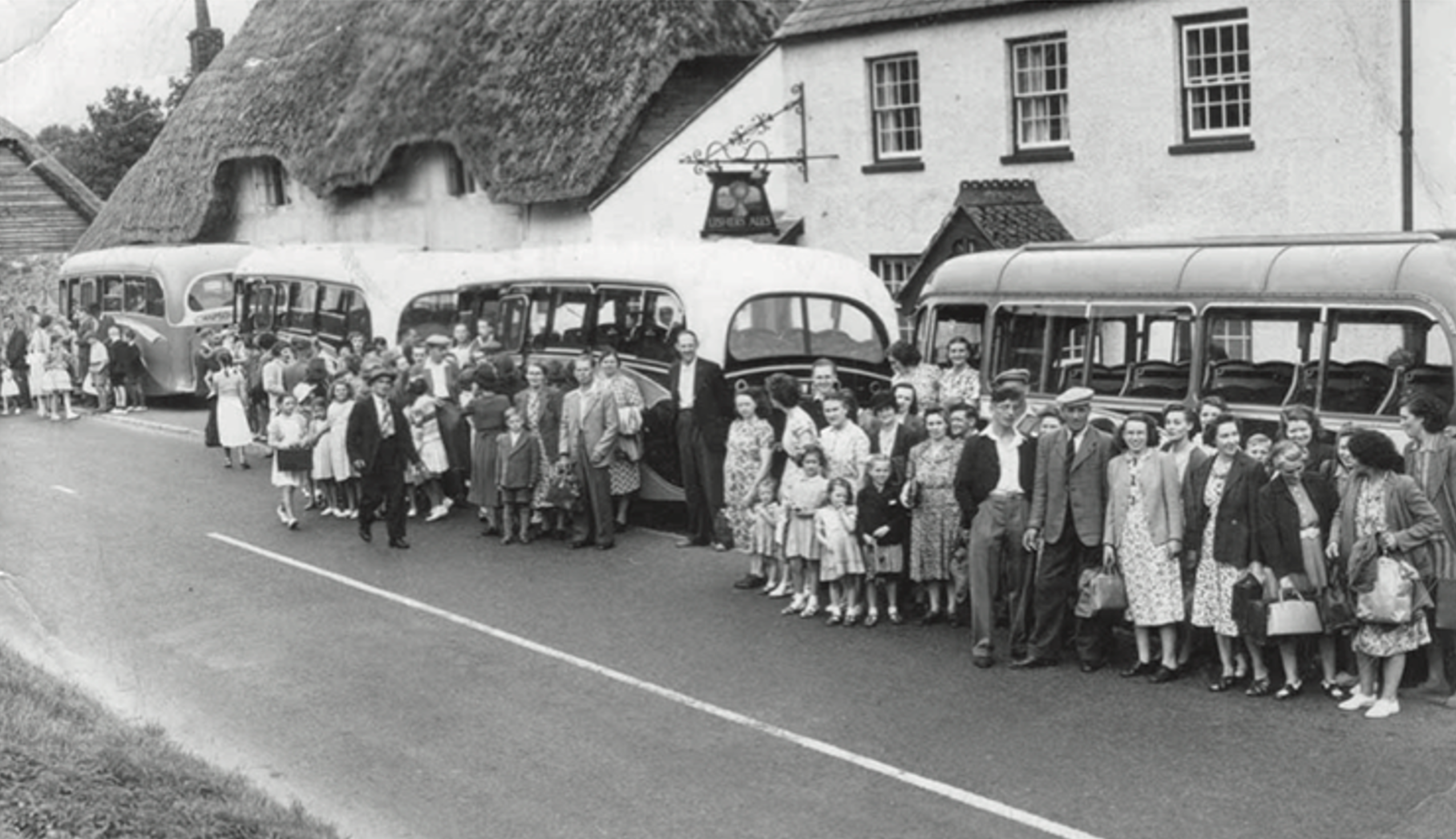 Crowd and coaches outside the pub in the 1950s